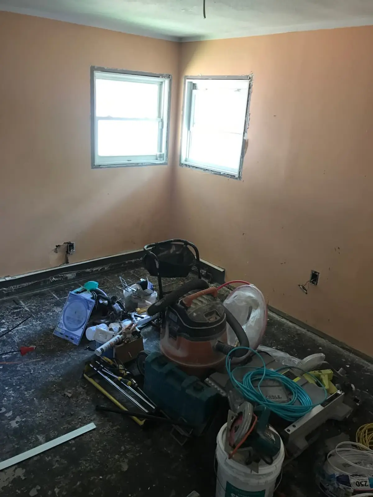 Selling a parent’s house after a move to care in Mastic: bedroom with tools and the flooring pulled up
