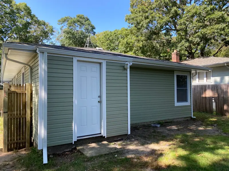 Rear of a ranch with new green siding, Mastic, NY